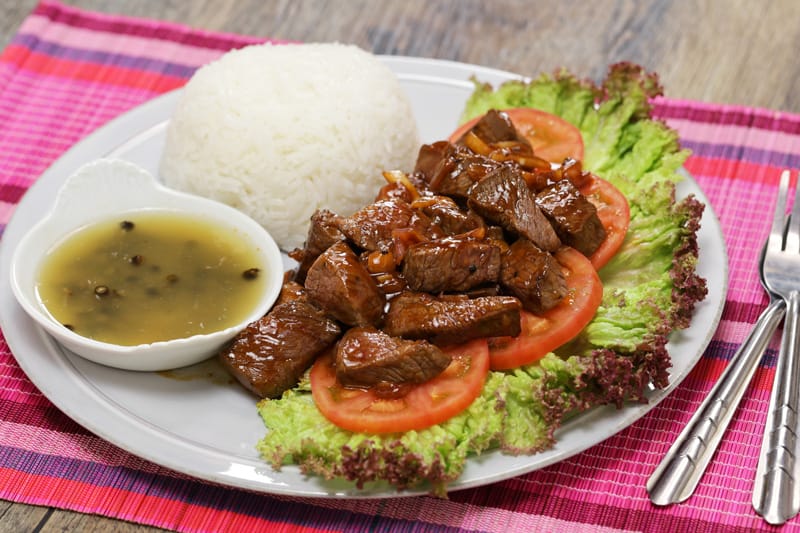 Lok Lak servito con il riso al vapore e la tradizionale salsa al pepe